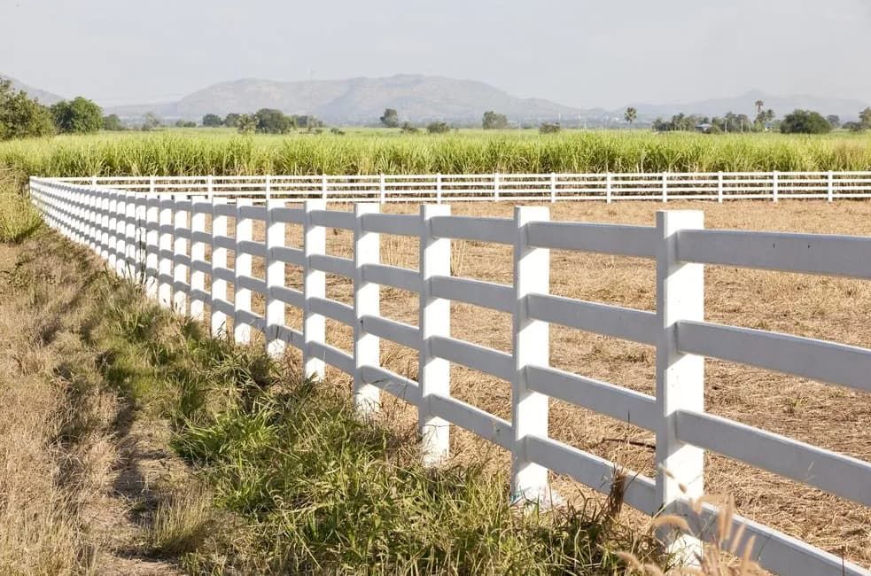 A White Fence Surrounds A Field With Mountains In The Background — Northstar Excavations In Alstonville, NSW