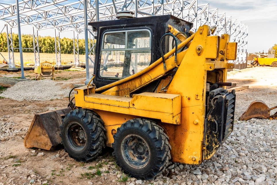 A Small Yellow Bulldozer Is Parked On A Gravel Road At A Construction Site — Northstar Excavations In Bangalow, NSW