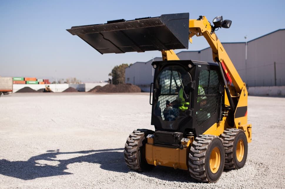 Yellow Skid-steer Loader with Raised Bucket, on a Gravel Surface — Northstar Excavations in Ballina, NSW