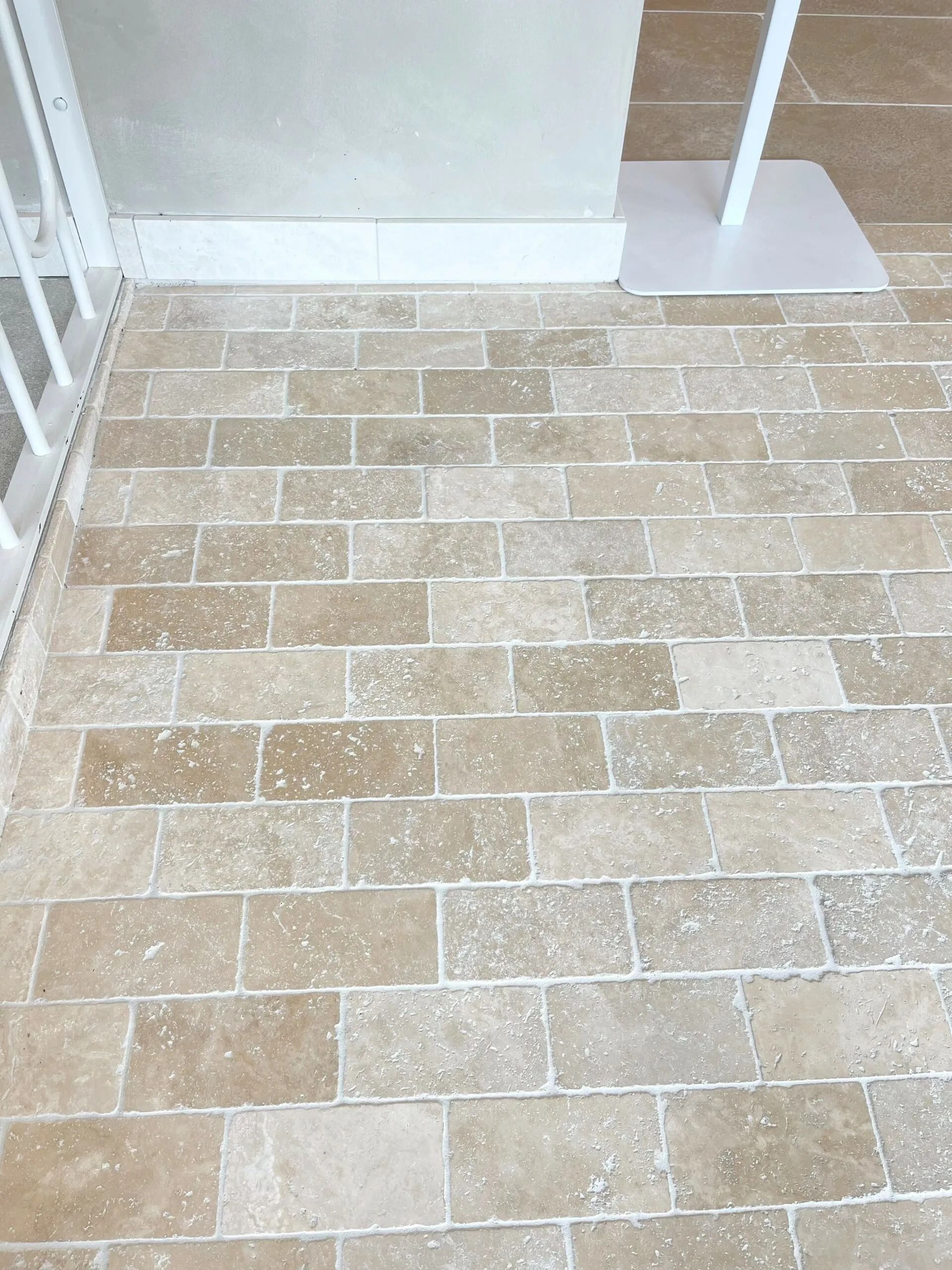Tan Brick-patterned Floor With White Accents and a Partial View of a White Barrier and Stand — Hunter Valley Bricks & Pavers in Scone, NSW