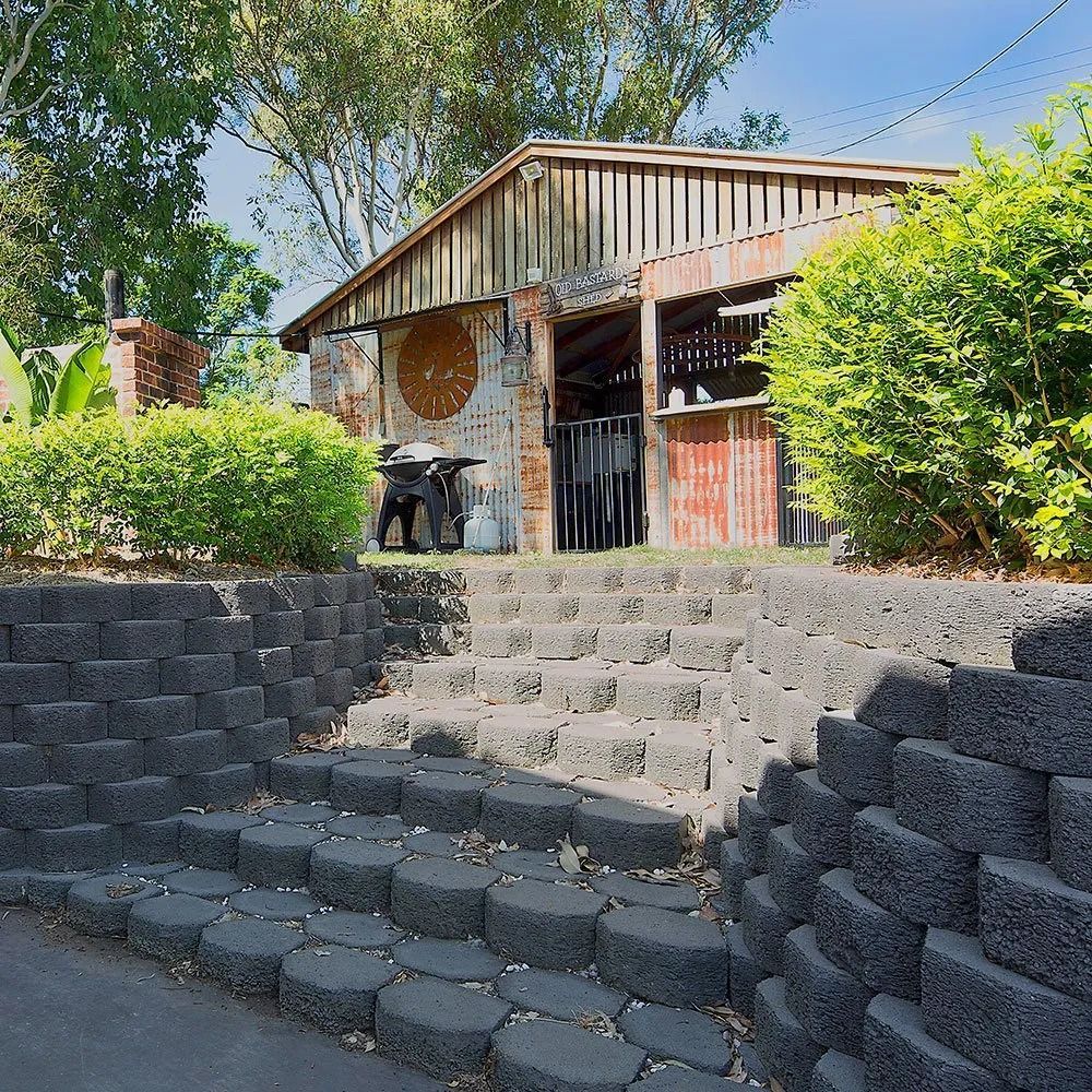 Stone Steps Leading to a Weathered Wooden Building With a Grill — Hunter Valley Bricks & Pavers in Scone, NSW