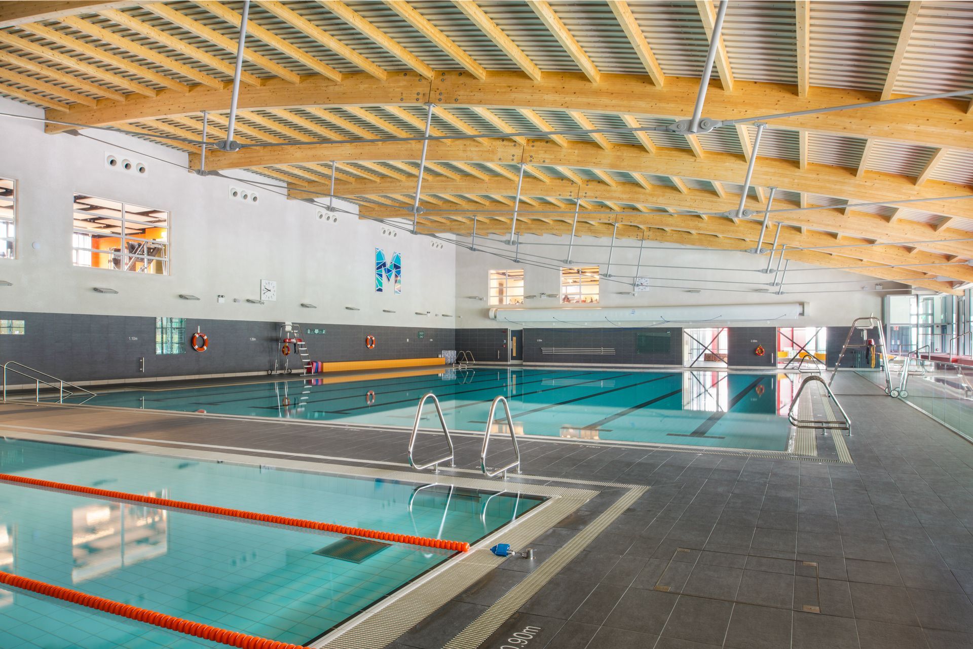 A large indoor swimming pool with a wooden ceiling