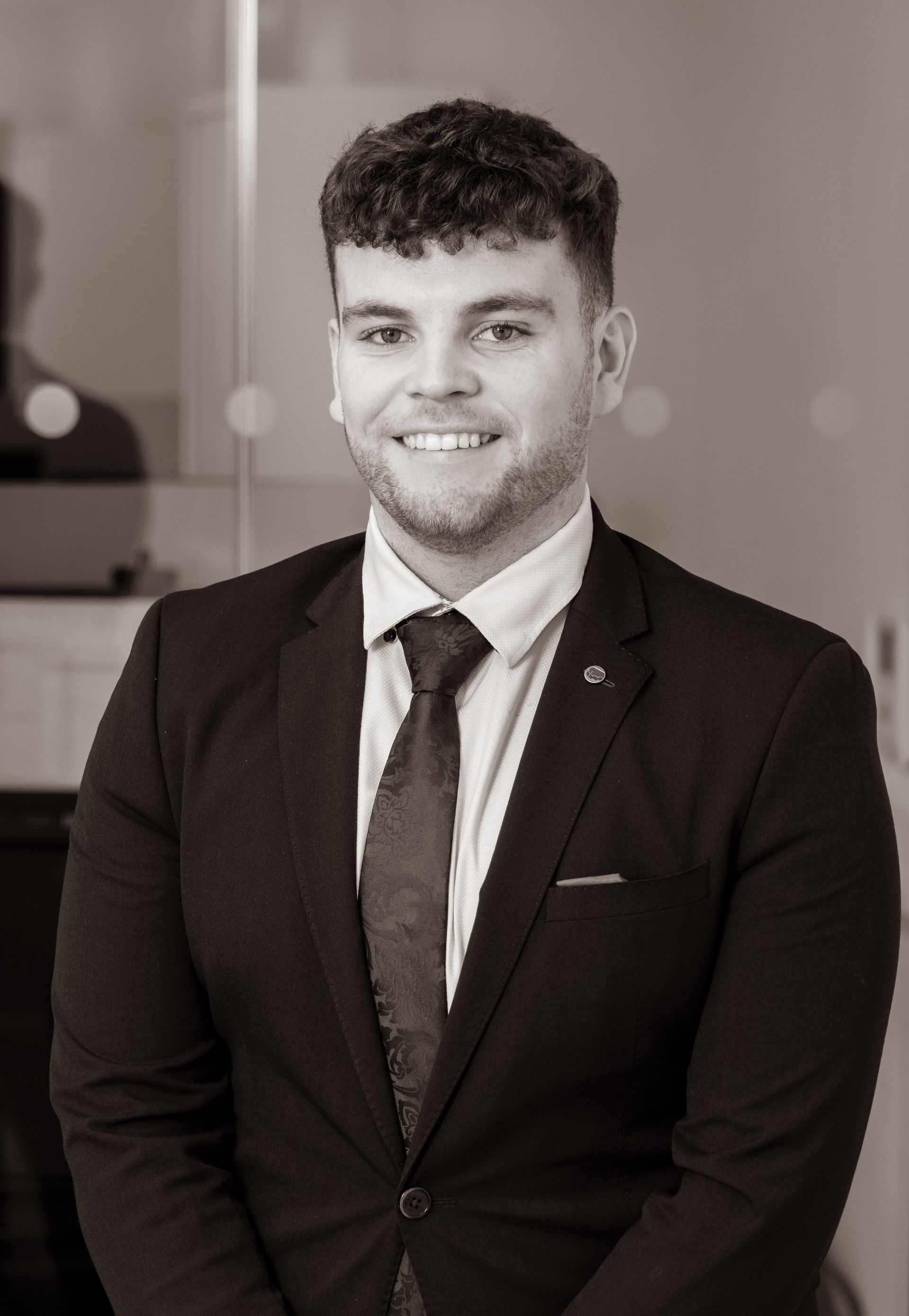 A man with a beard is wearing a suit and tie.