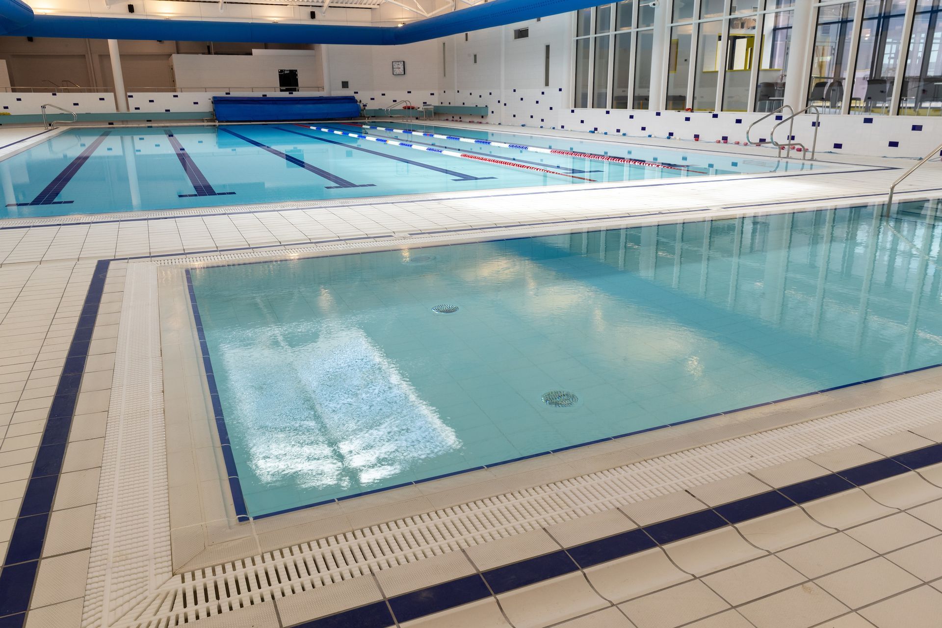 A large indoor swimming pool with blue and white tiles