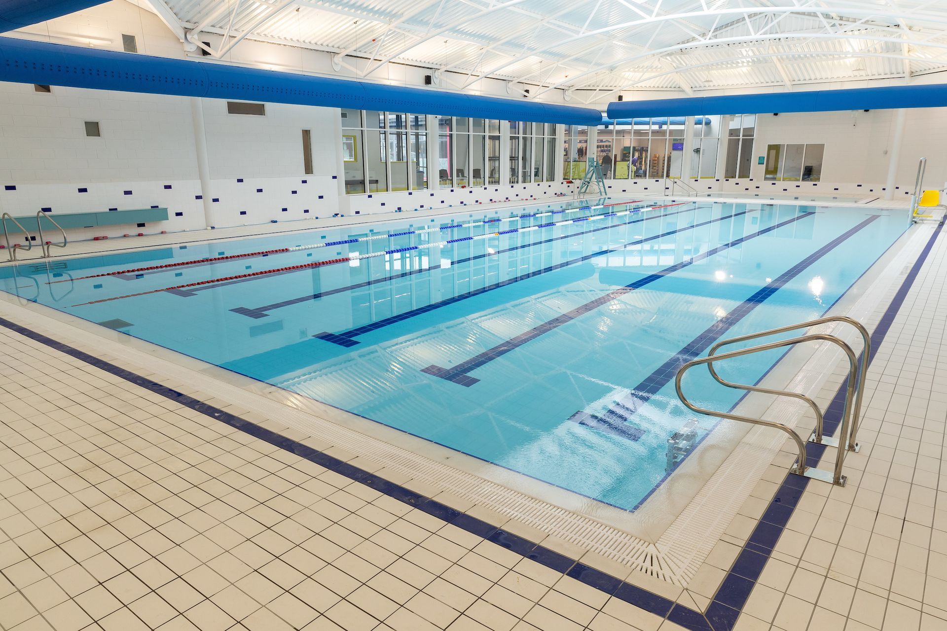A large indoor swimming pool with stairs leading to it.