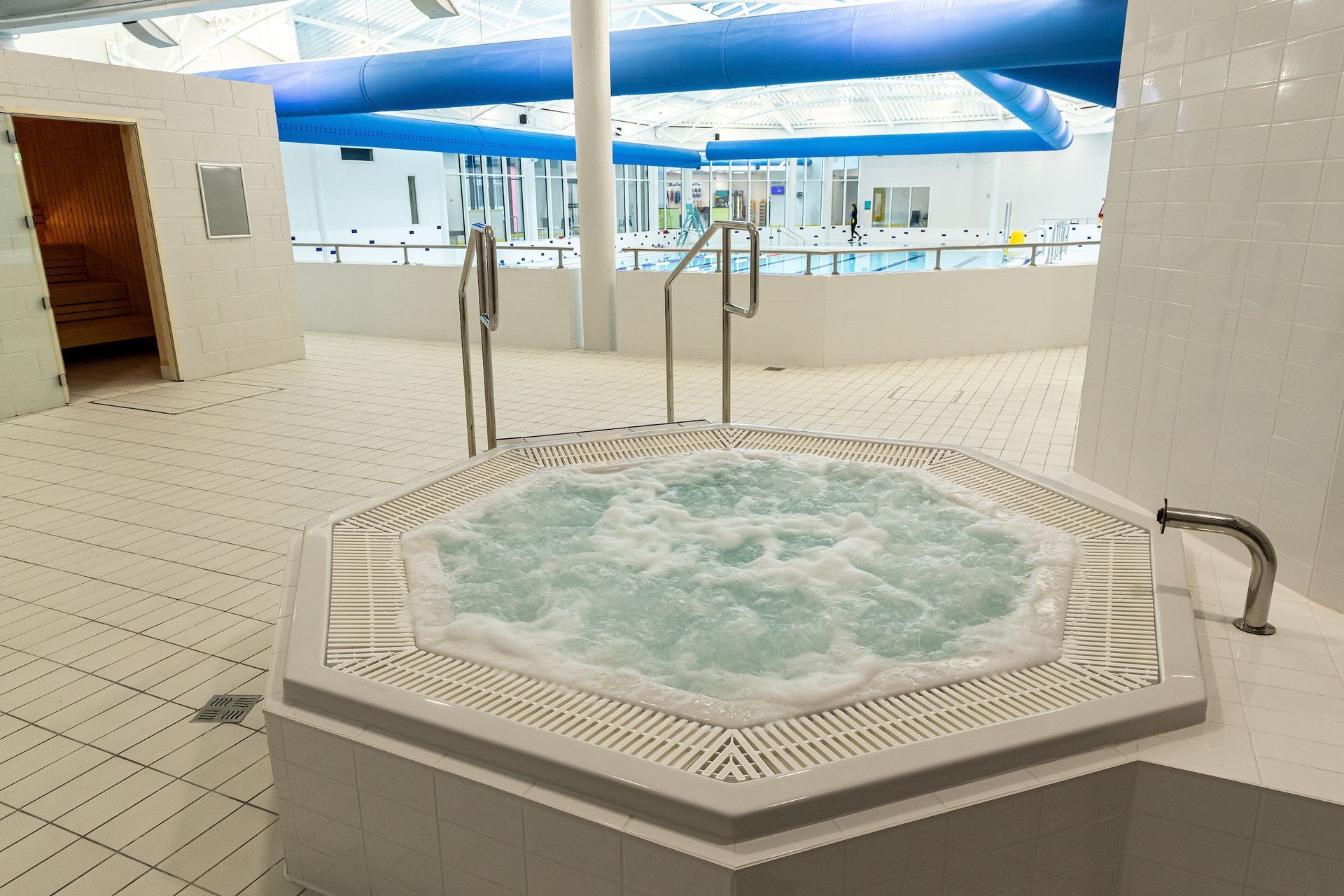A hot tub is in the middle of a swimming pool.