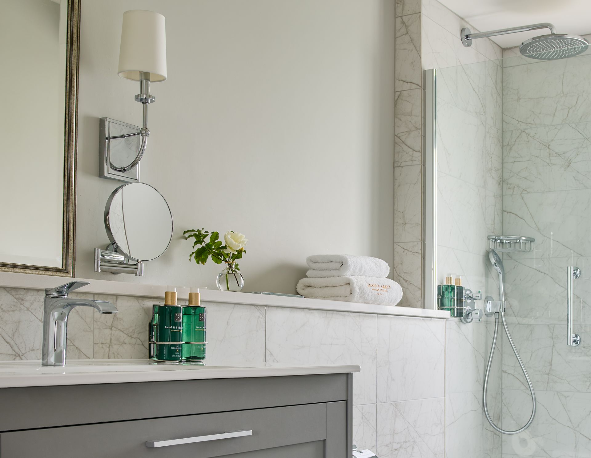 A bathroom with a sink a mirror and a shower