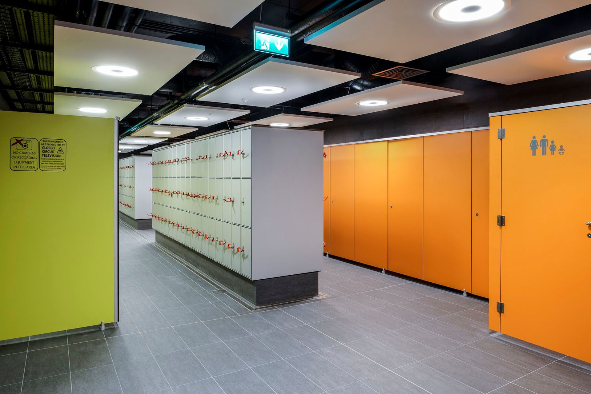 A long hallway with orange lockers and yellow walls.