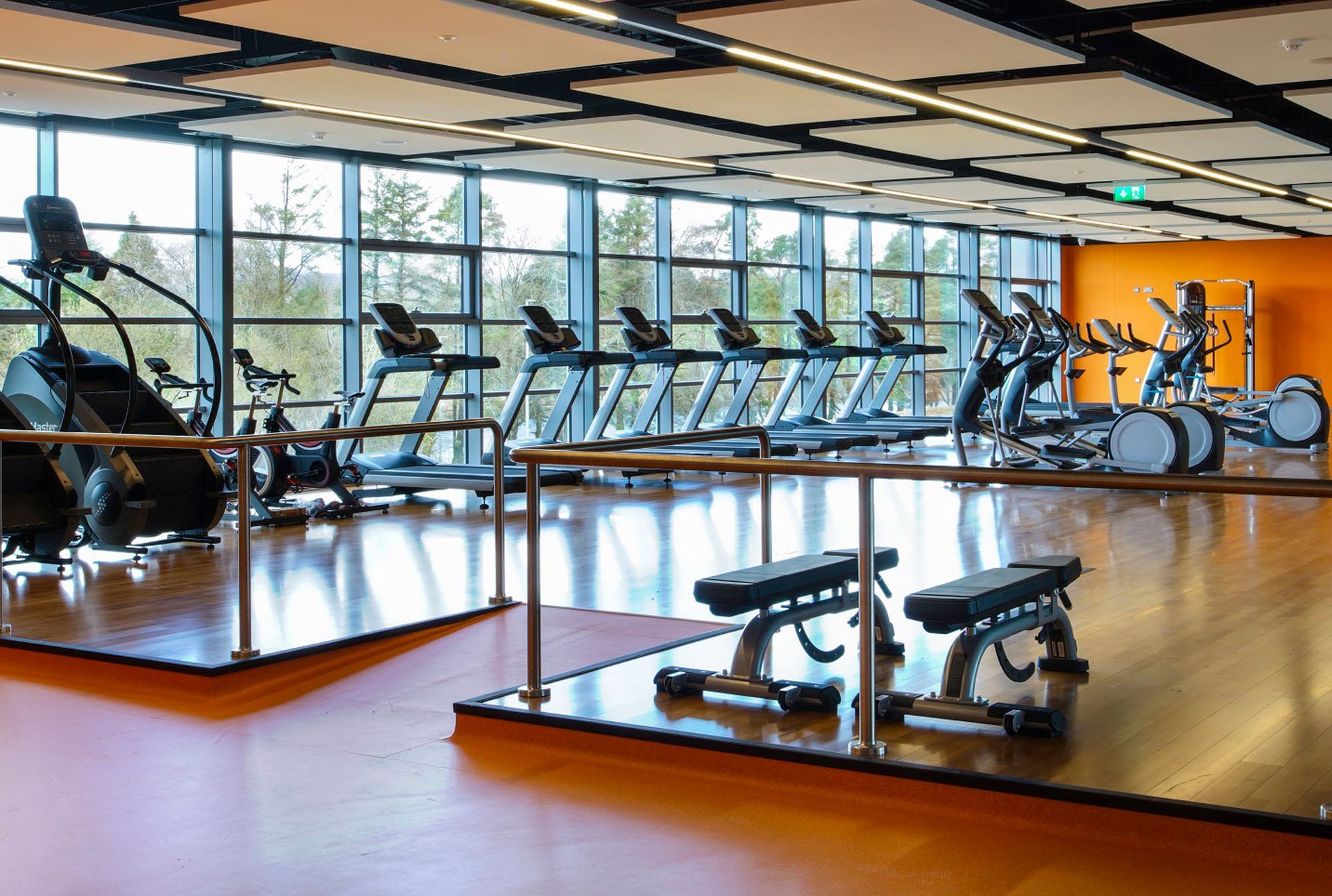 A gym filled with lots of exercise equipment and a bench.