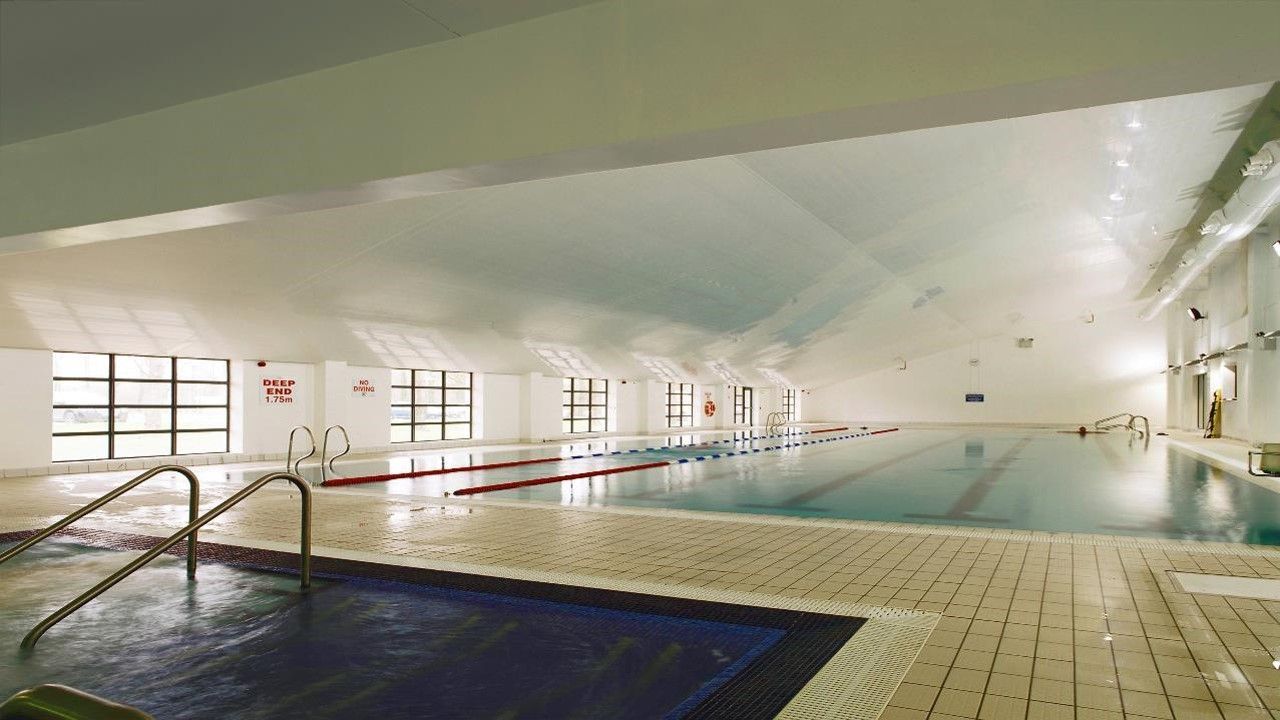A large indoor swimming pool with stairs leading to it.