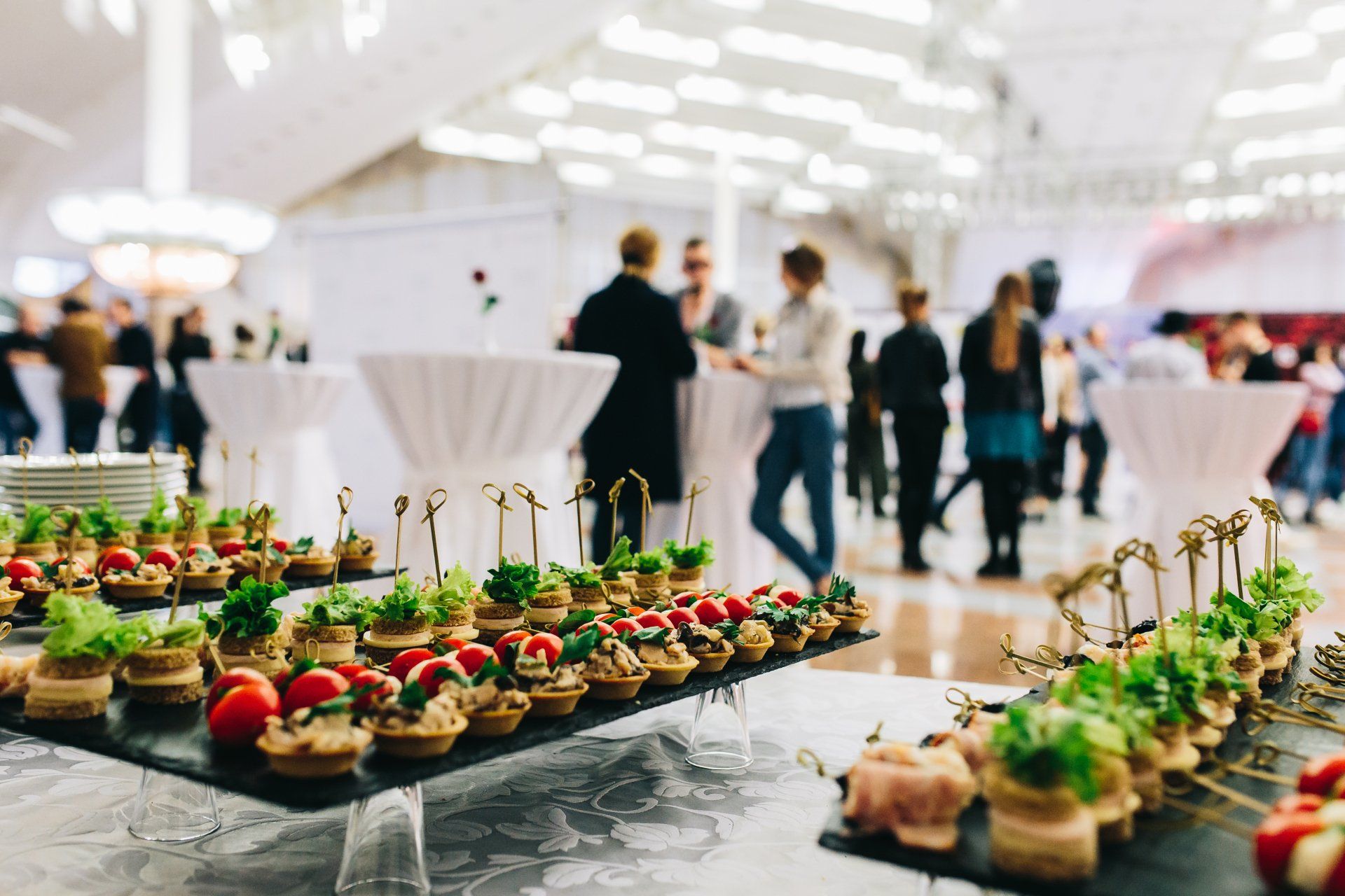 A buffet with a lot of food and people standing around tables.