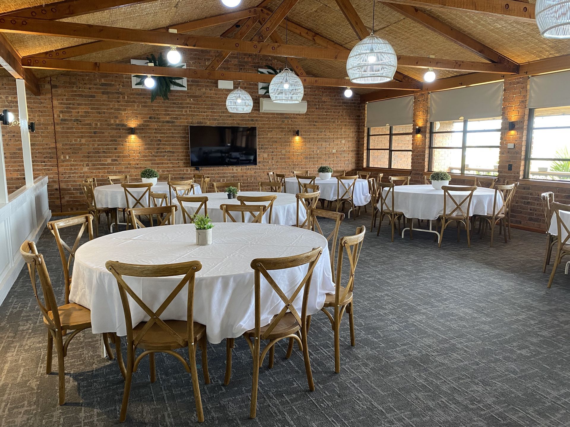 A Large Room Filled with Tables and Chairs and a Flat Screen Tv - Function Venue in Hillvue, NSW