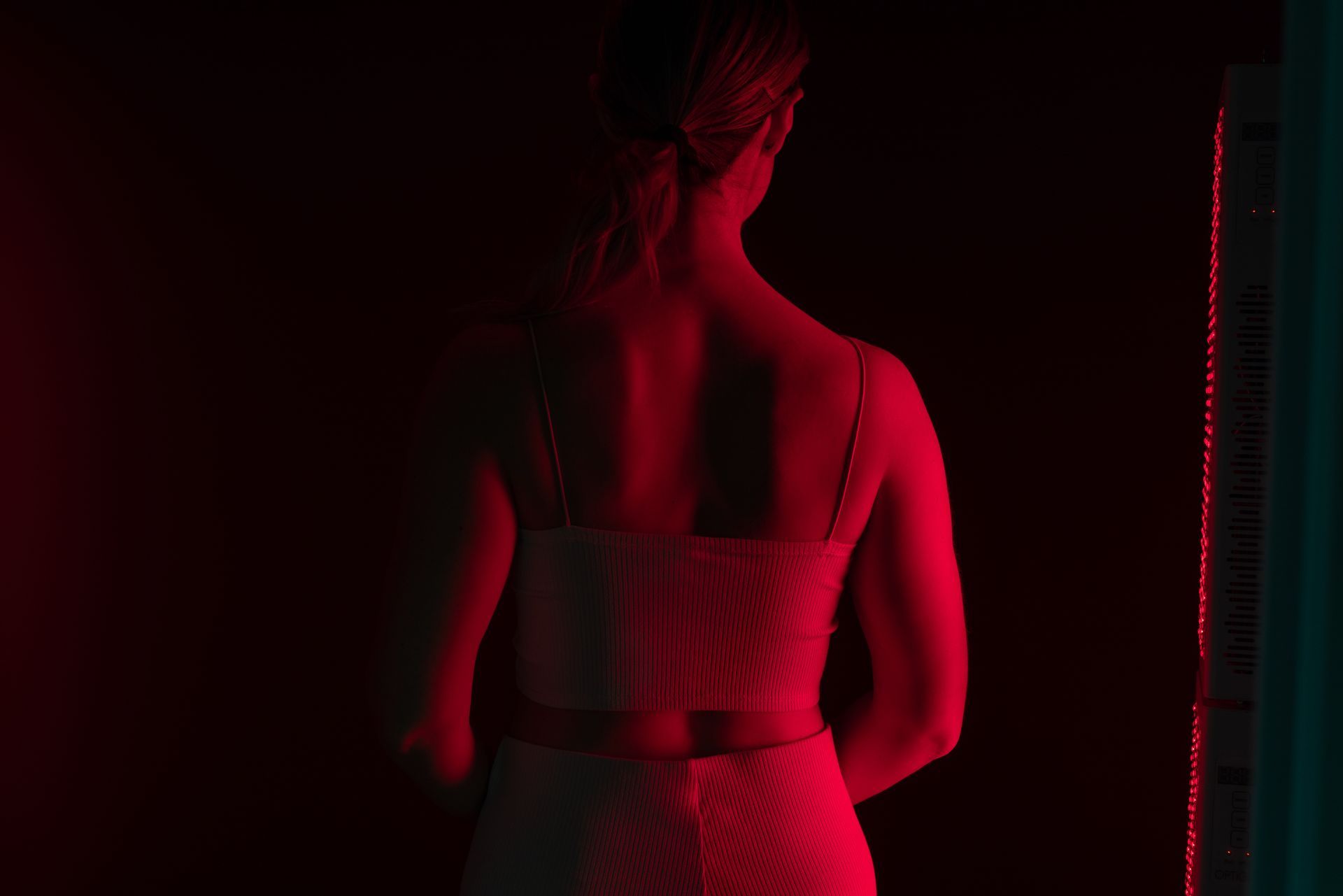 A woman is getting a red light treatment on her face.