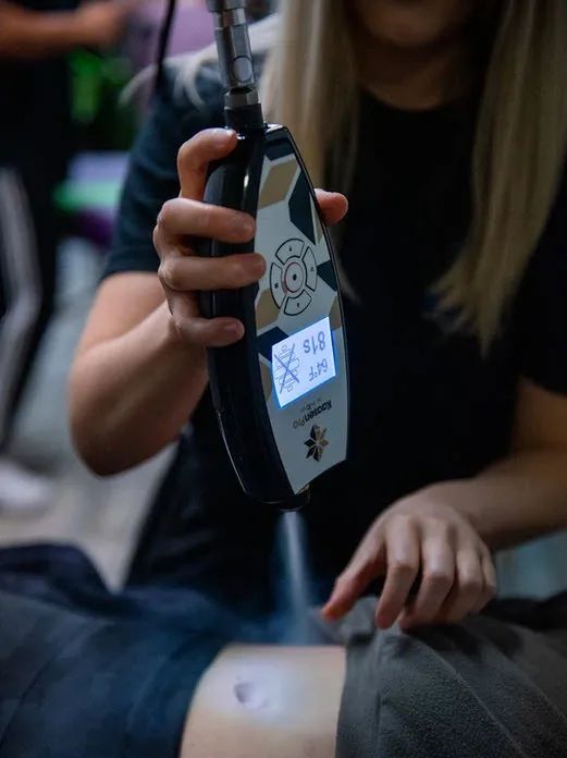 A woman is holding a device that says x on it