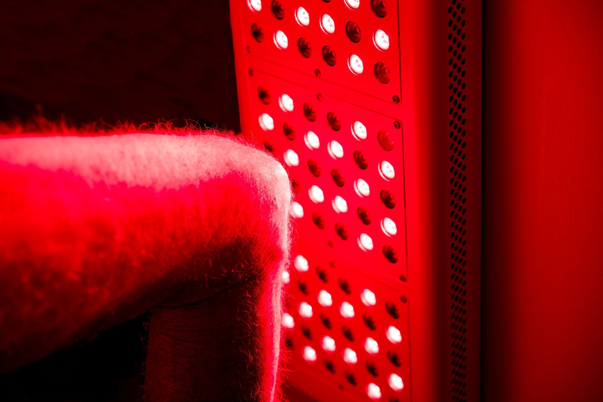 A person is sitting on a chair with a red light on their back.