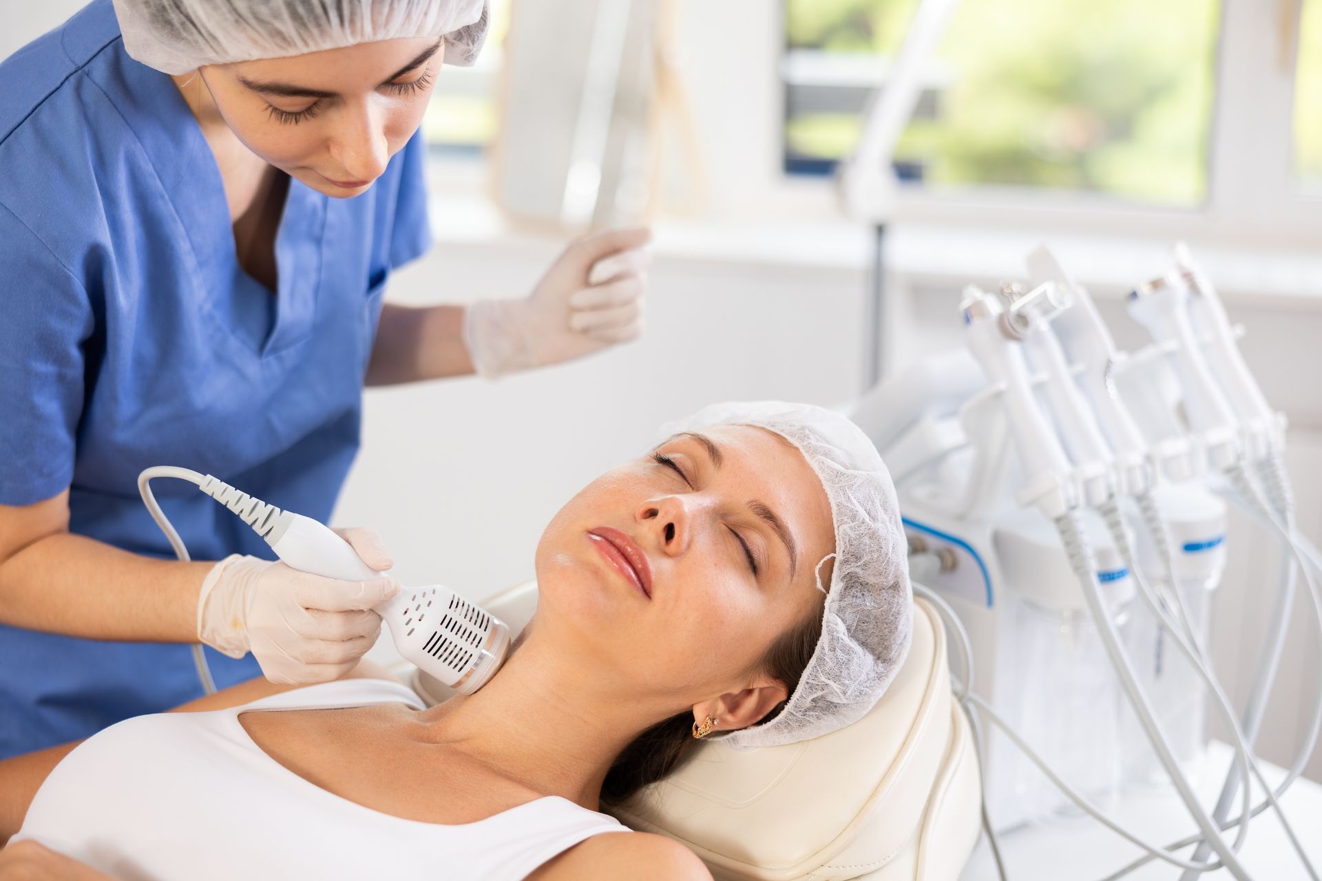 A woman is getting a precision cryotherapy treatment on her neck.