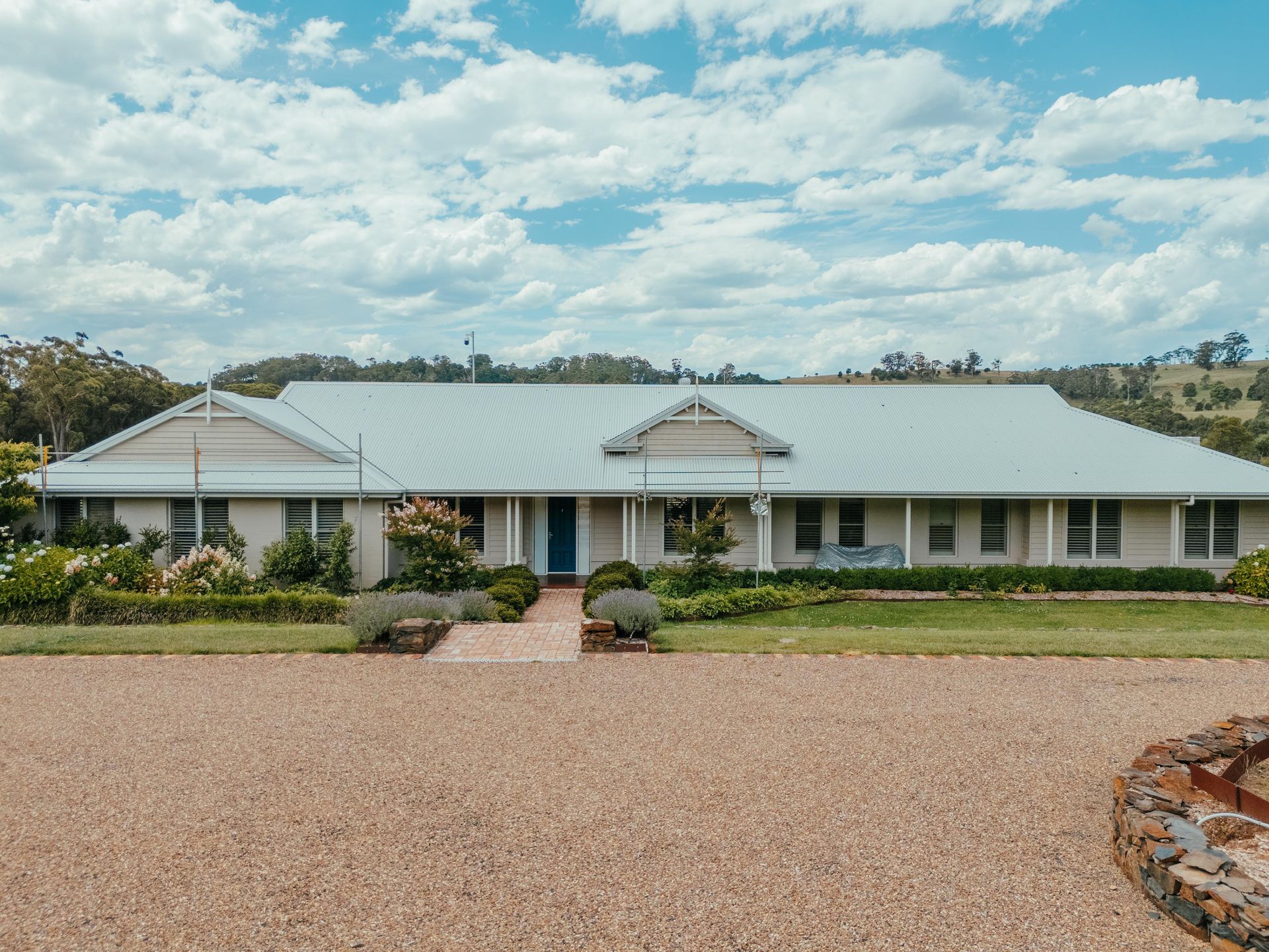 Pressure Washer Cleaning White House Siding Near a Window — Mittagong Painting in Mittagong, NSW