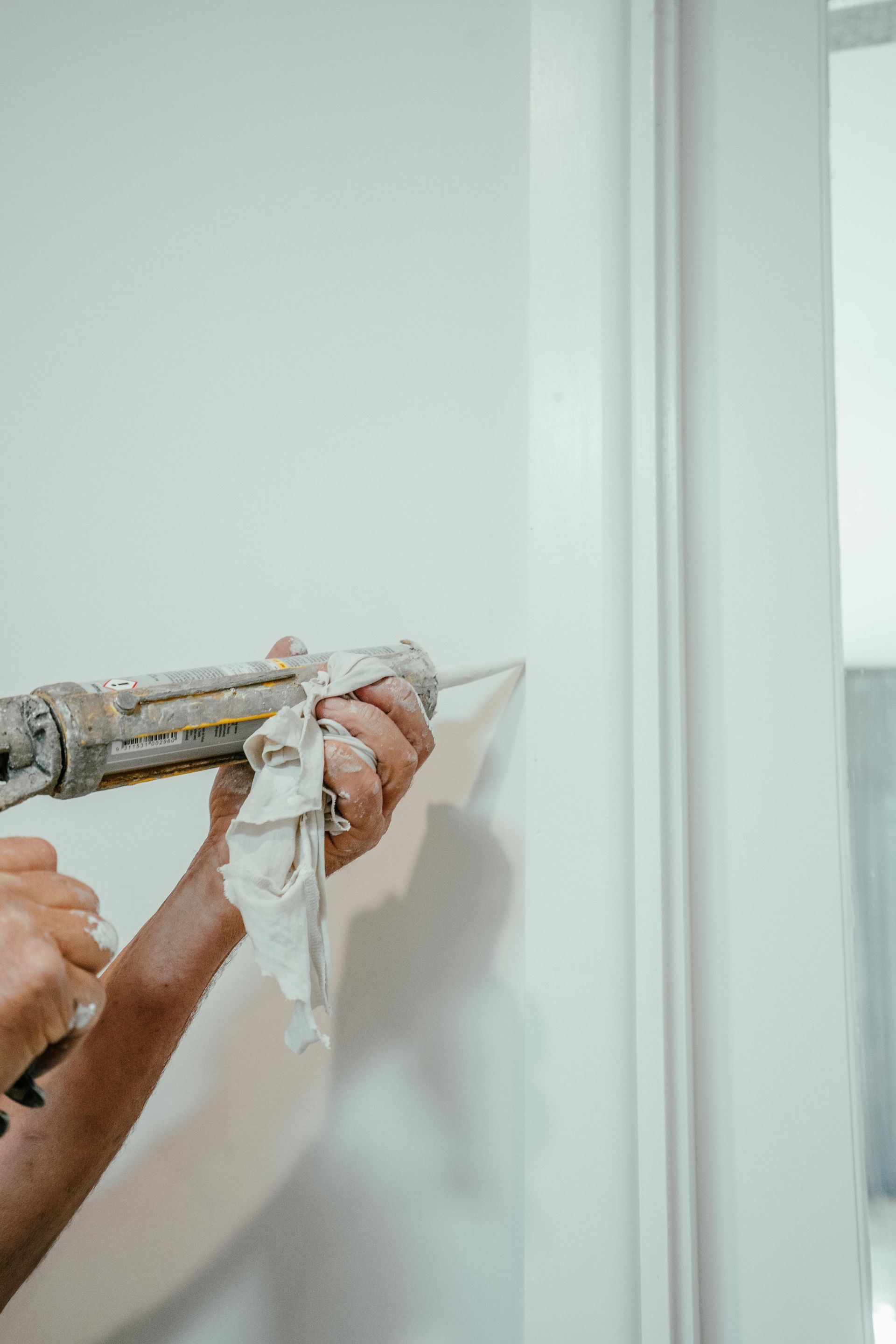 Pressure Washer Spraying a White House Wall, Removing Dirt Streaks — Mittagong Painting in Moss Vale, NSW