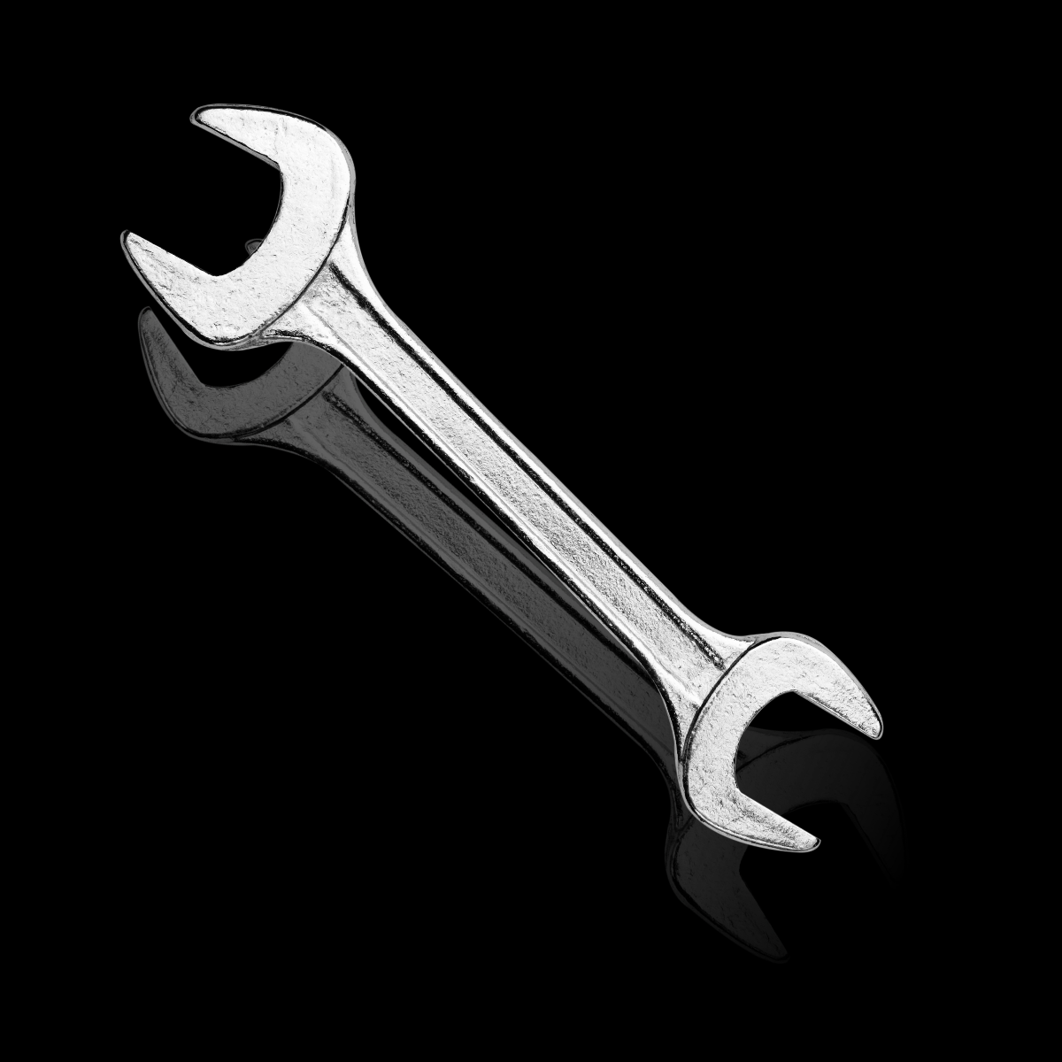 Two silver wrenches crossed on a black background