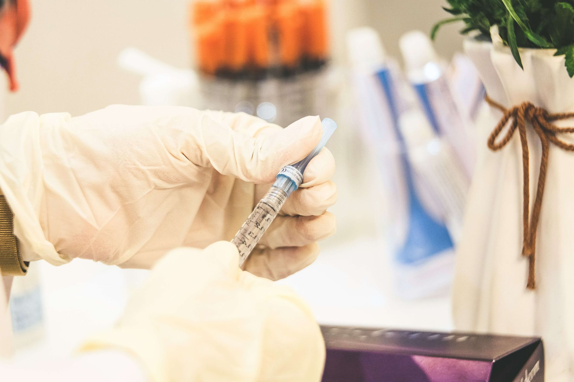 Gloved hands handling a syringe in a medical setting