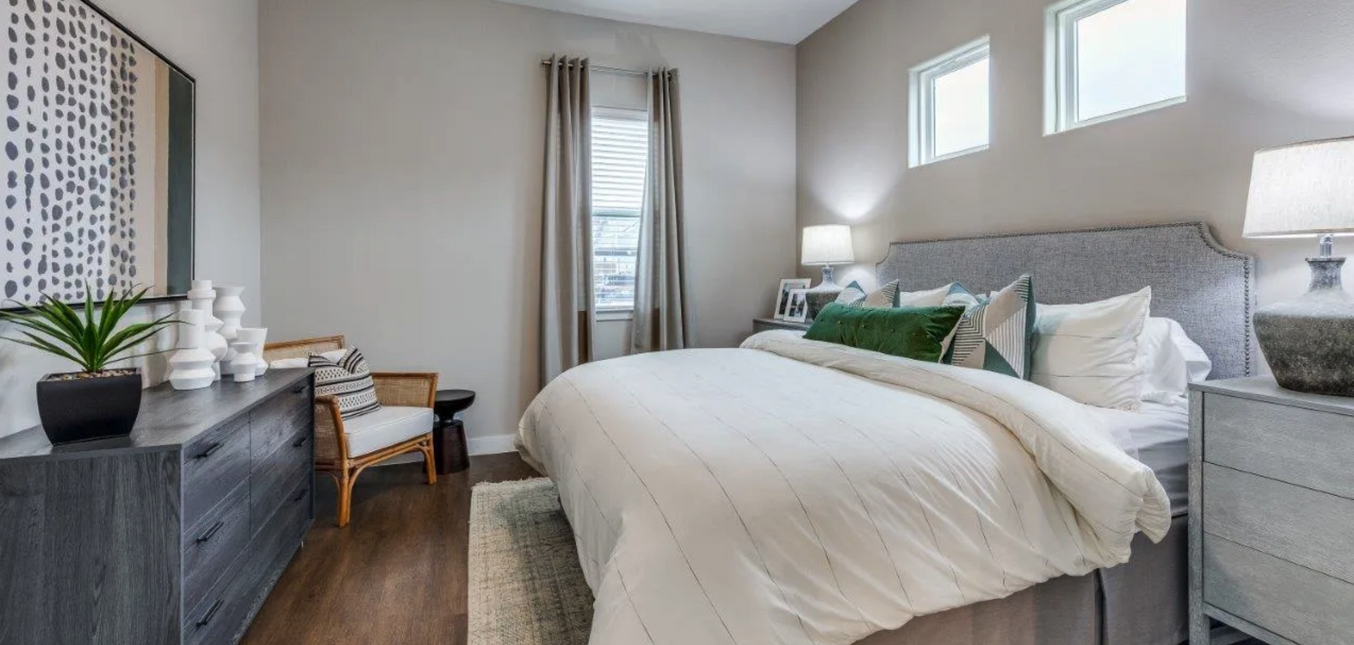 A bedroom with a bed, dresser, nightstand, chair and window.