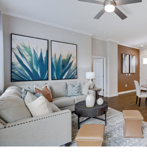 A living room with a couch and a ceiling fan.