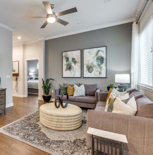A living room filled with furniture and a ceiling fan.