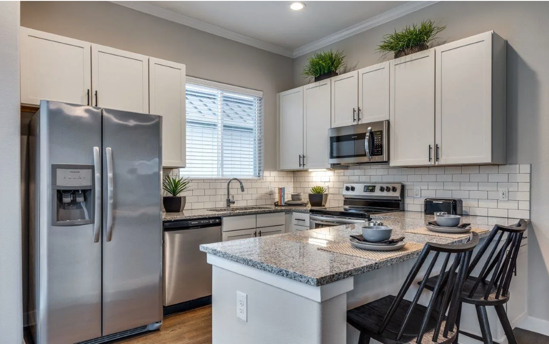 A kitchen with stainless steel appliances and granite countertops.