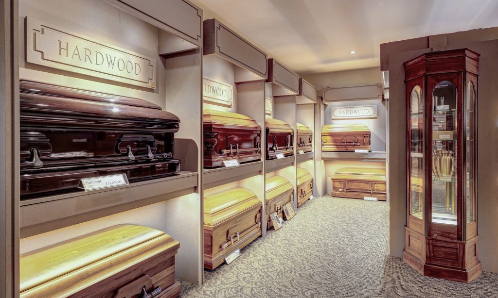A room filled with lots of coffins and a clock.