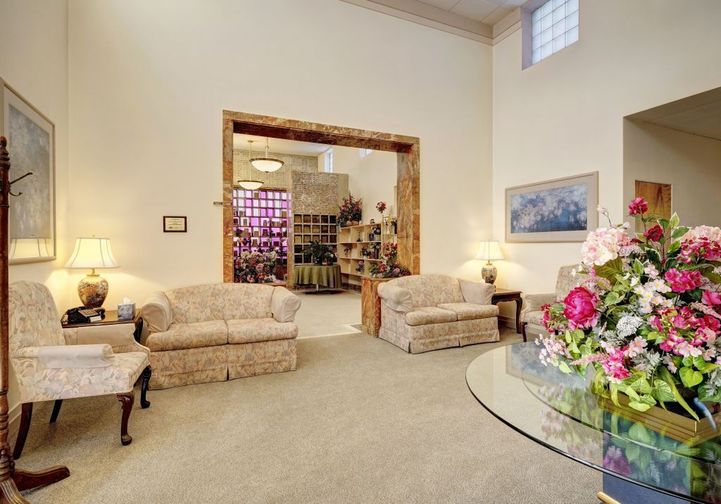 A living room with a couch , chair , table and flowers