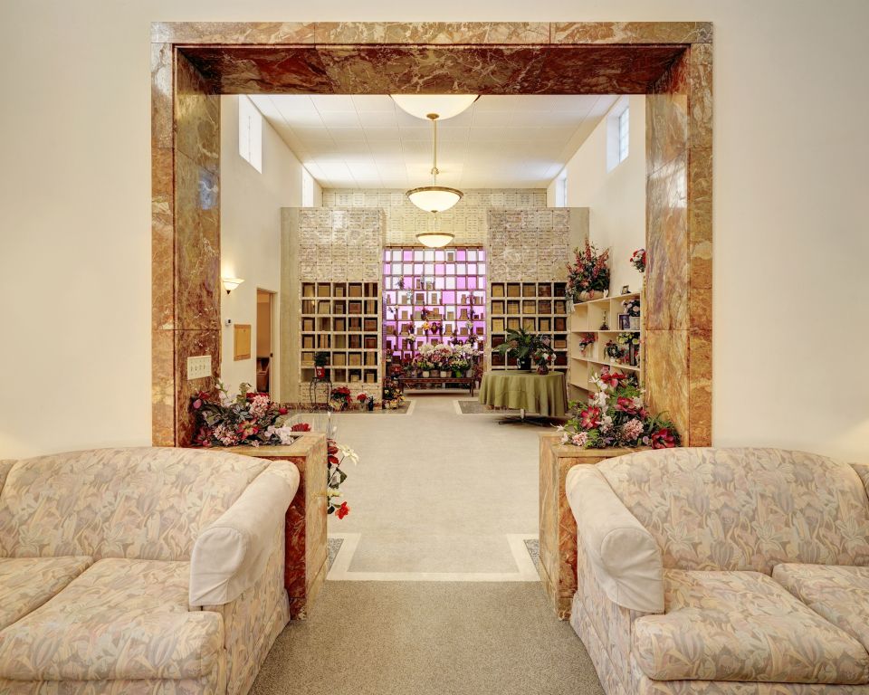 A living room with two couches and a table with flowers on it