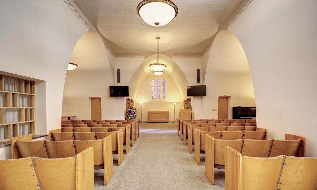 The inside of a church with rows of wooden benches