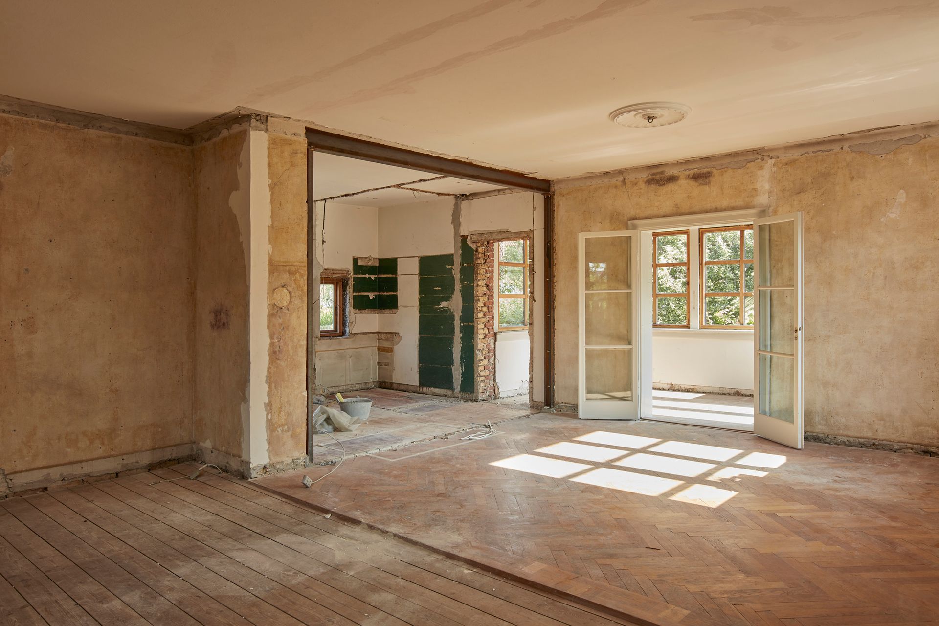 An empty room with a wooden floor and a sliding glass door.