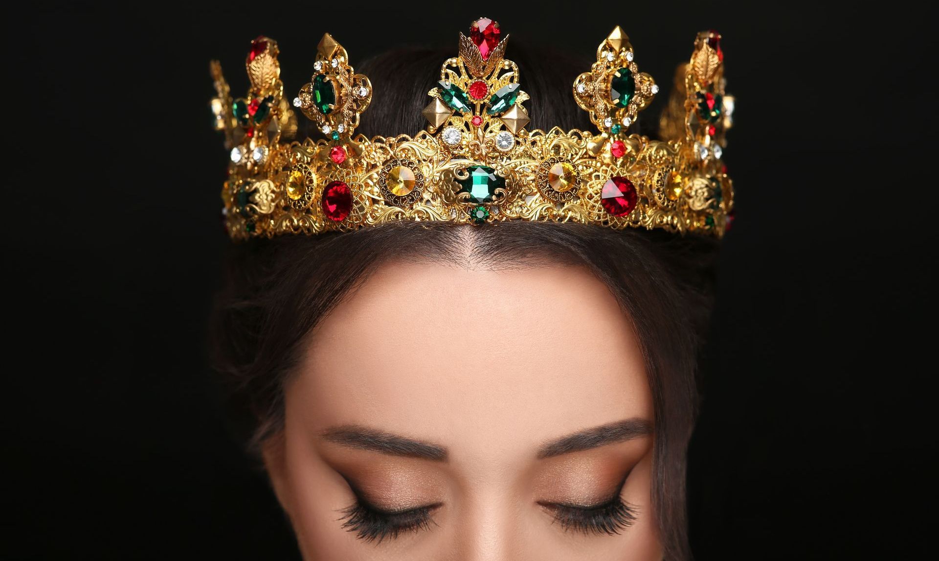 A woman is wearing a gold crown on her head.