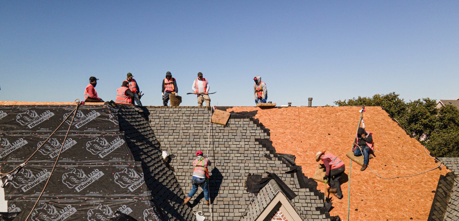 Group of roofers working on the roof of a residential building
