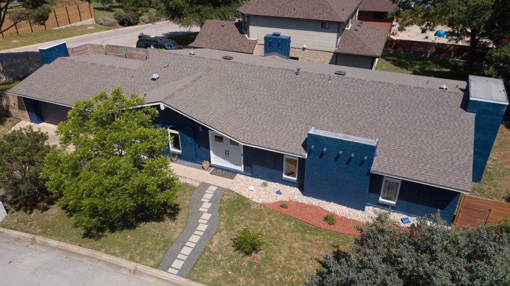 an aerial view of a blue house with a gray roof