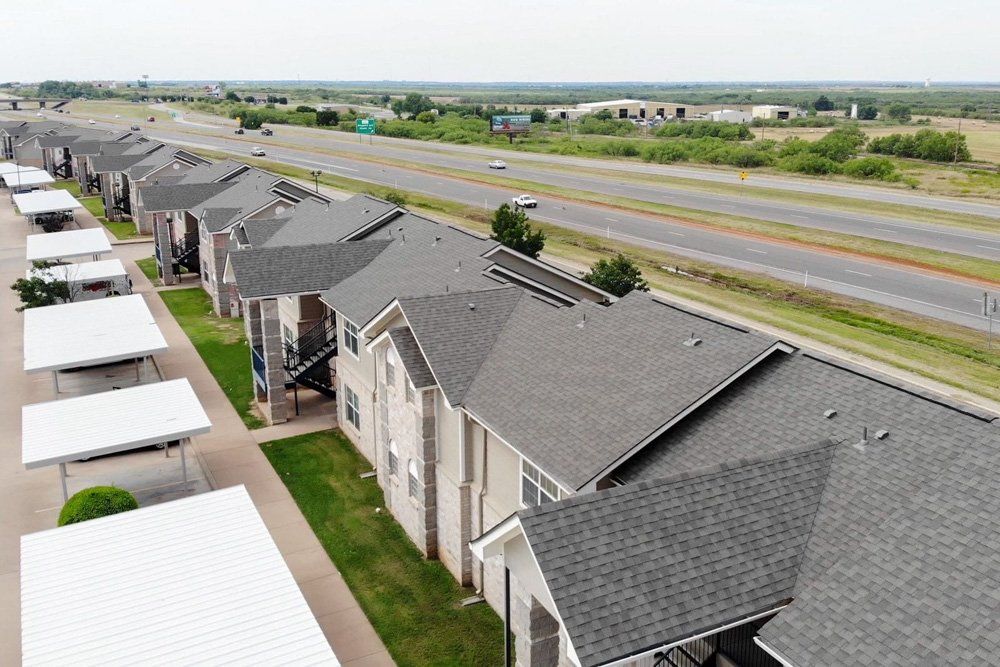 an aerial view of a row of apartment buildings next to a highway .