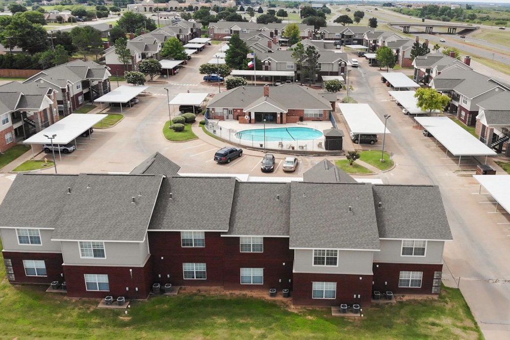 an aerial view of a apartment complex with a pool in the middle