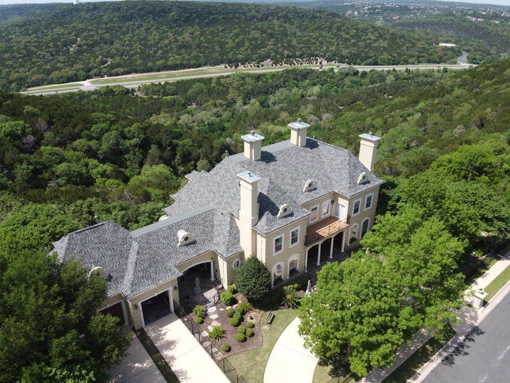 an aerial view of a large house surrounded by trees .