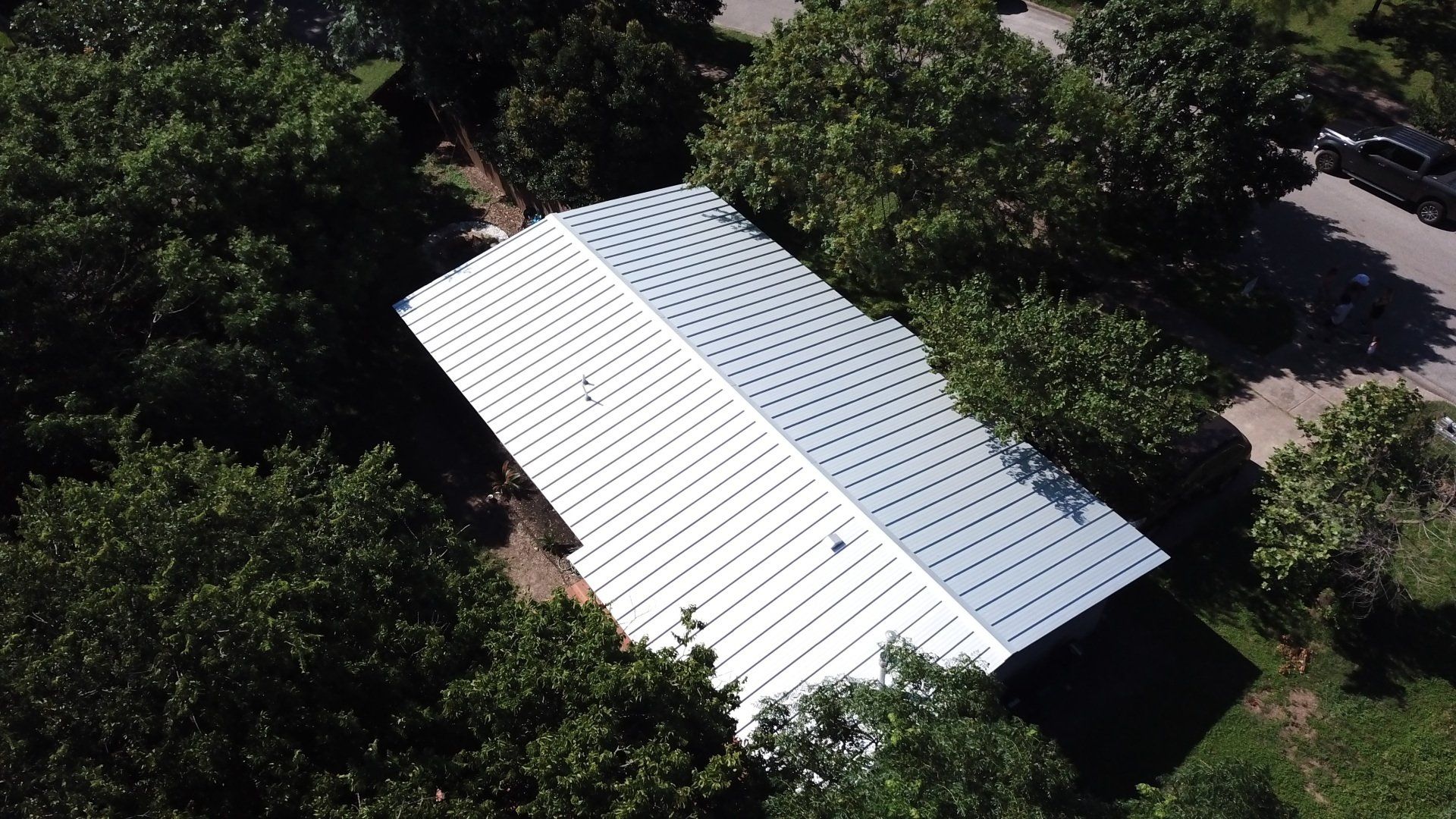 Brand new metal roof on residential home surrounded by green trees