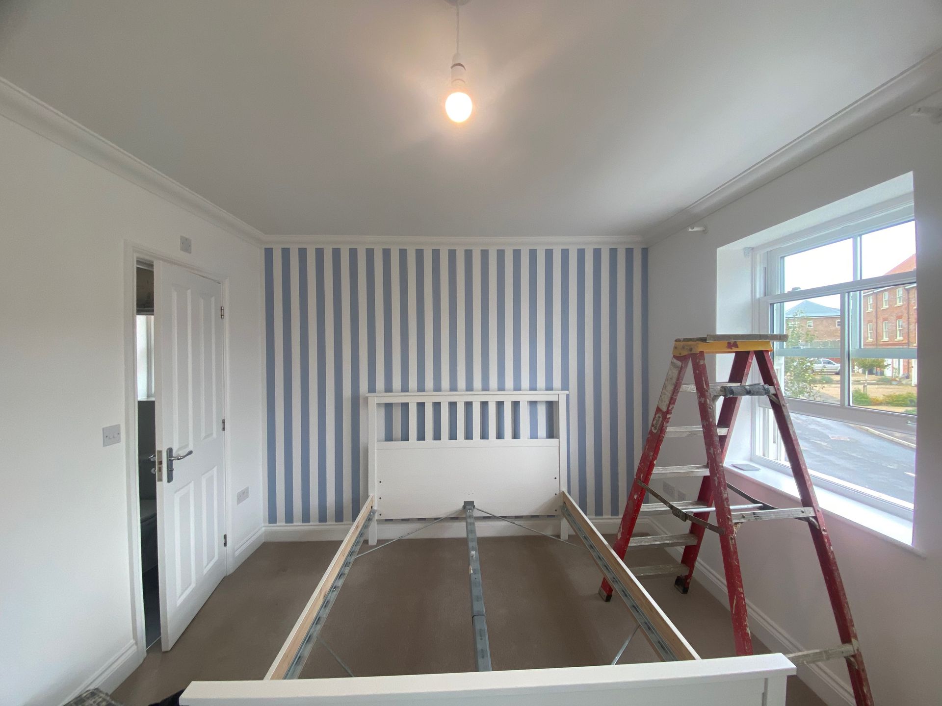 Master bedroom feature wall blue & white stripe wallpaper