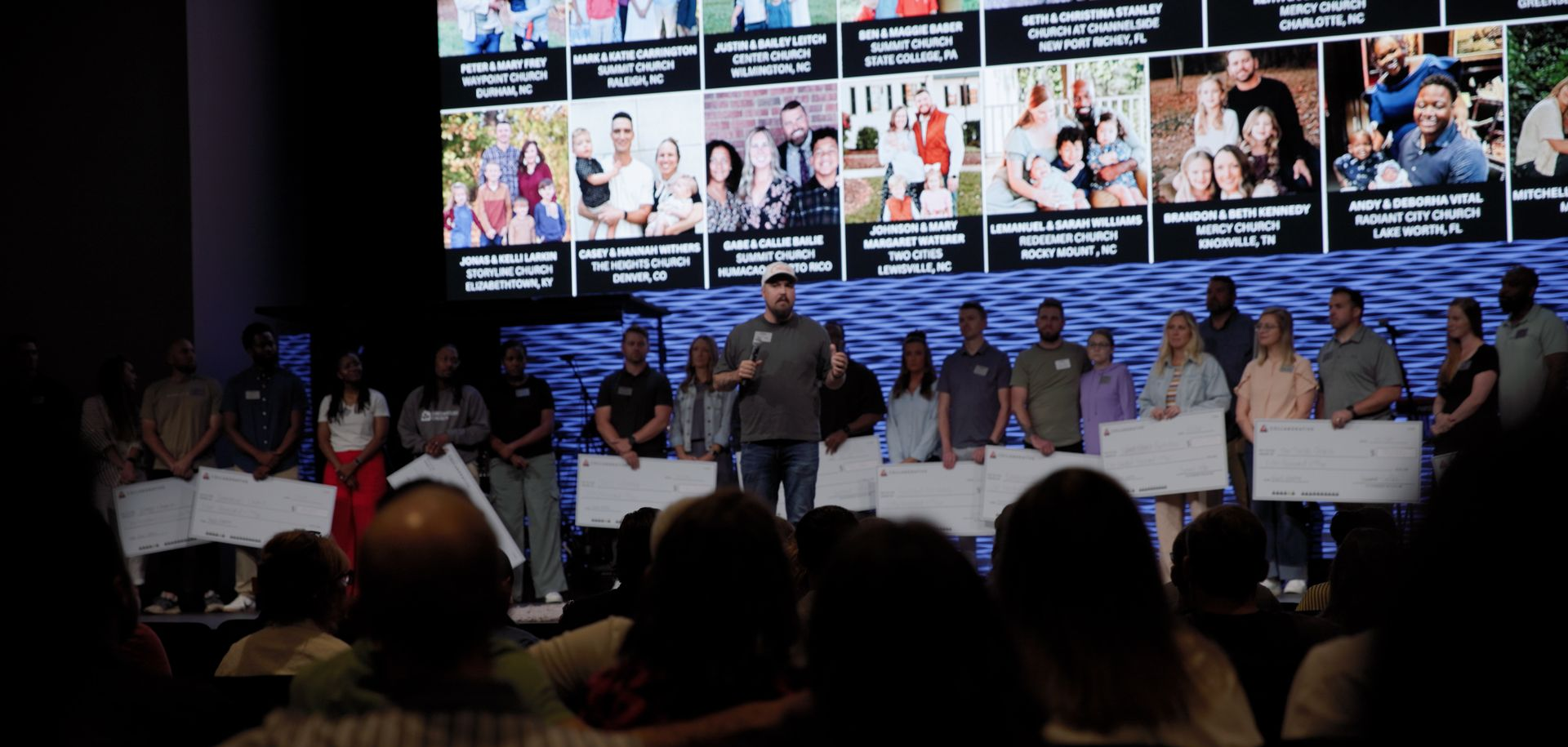 Panel discussion on a stage with speakers seated beneath multiple projected photos