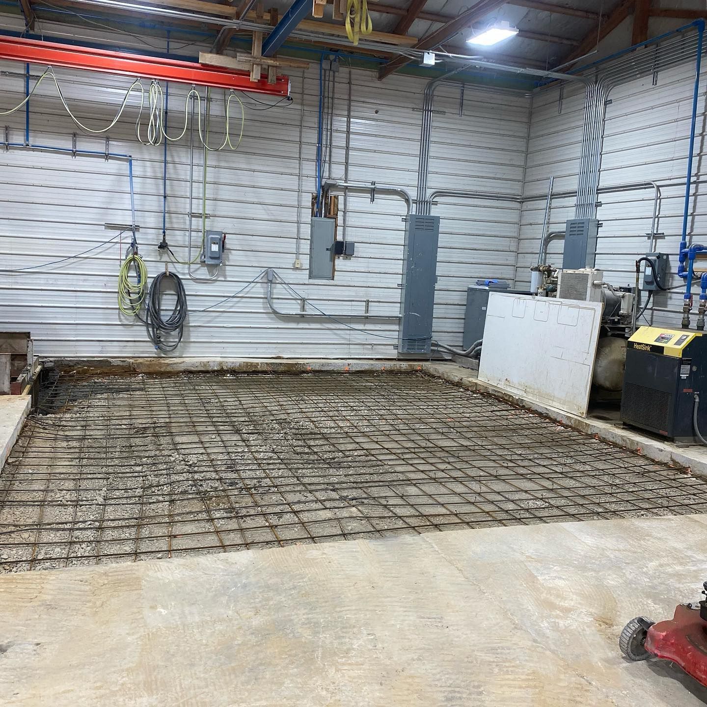 Concrete floor with rebar grid in an industrial space.