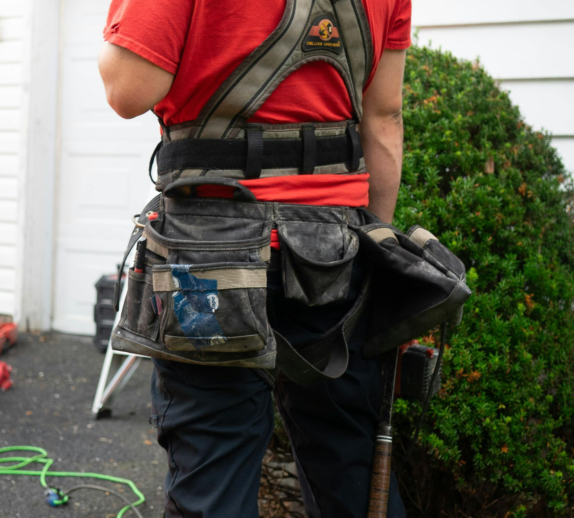 A man is cleaning the side of a building with a high pressure washer.
