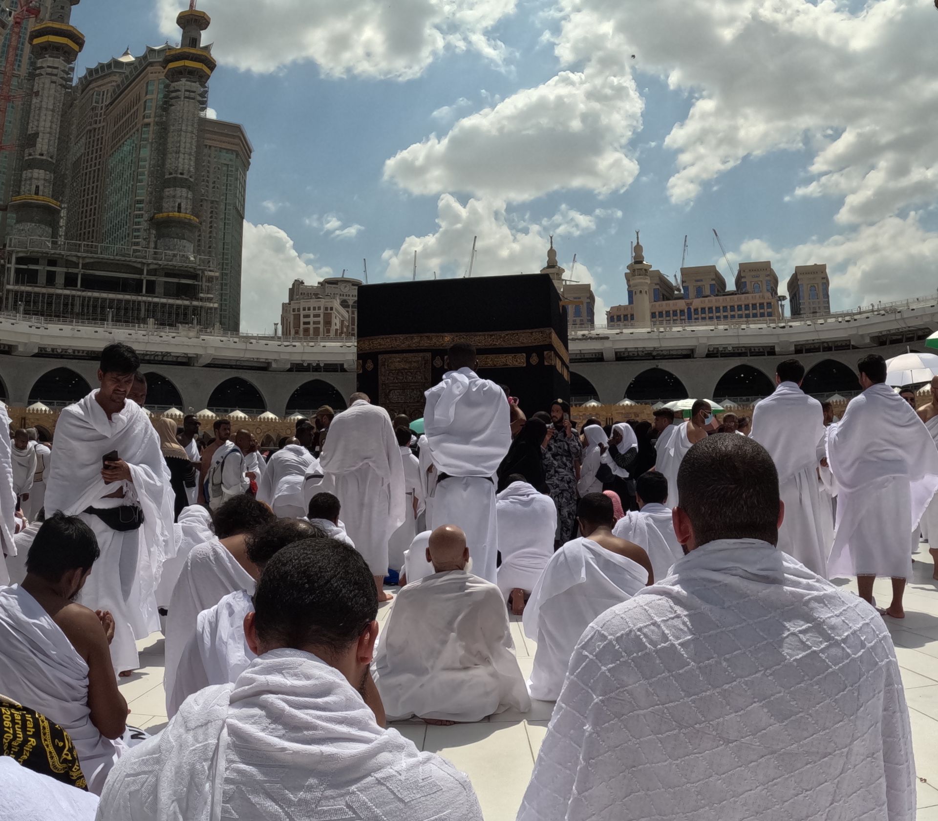 Een groep mensen die voor een kaaba zitten