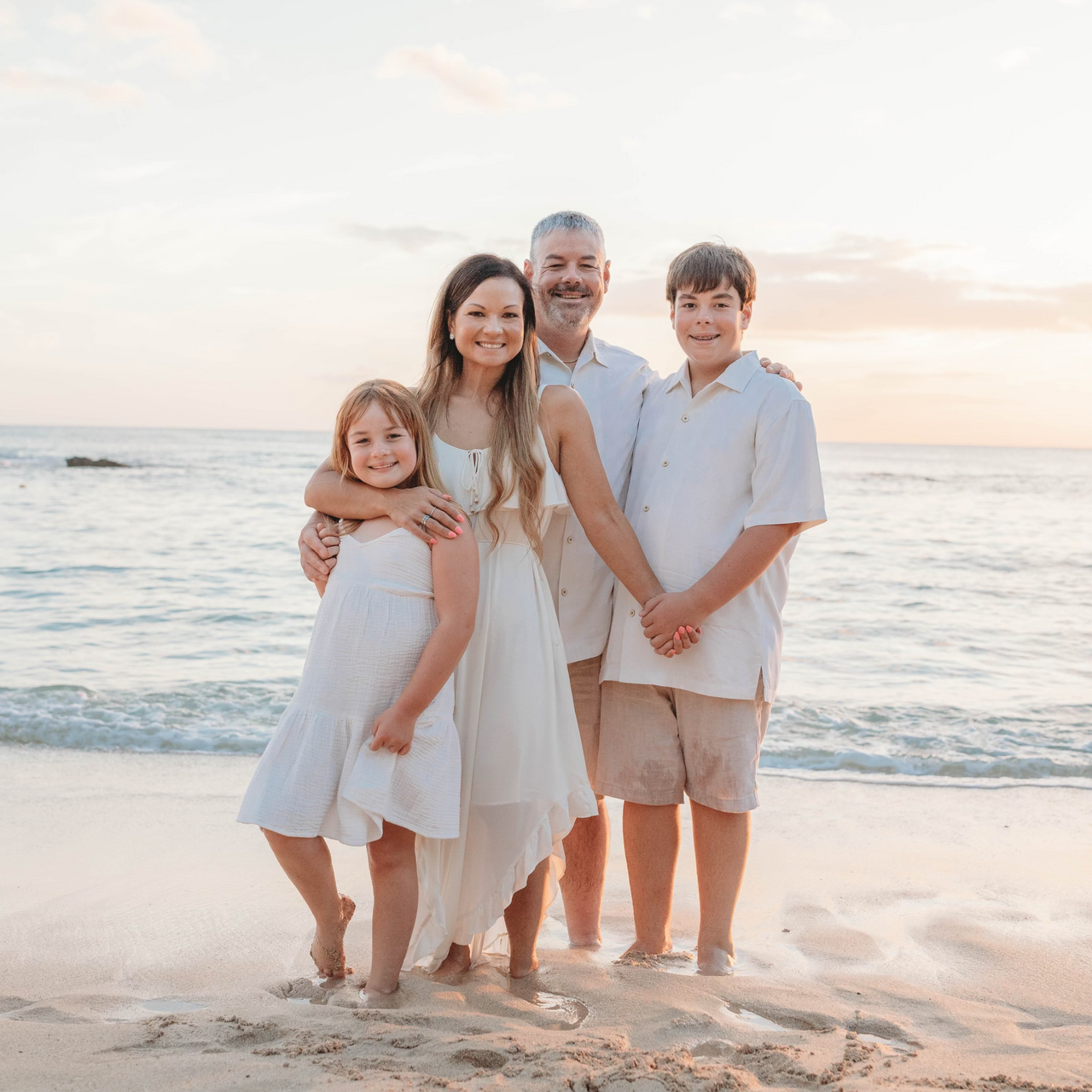 a family is posing for a picture on the beach .