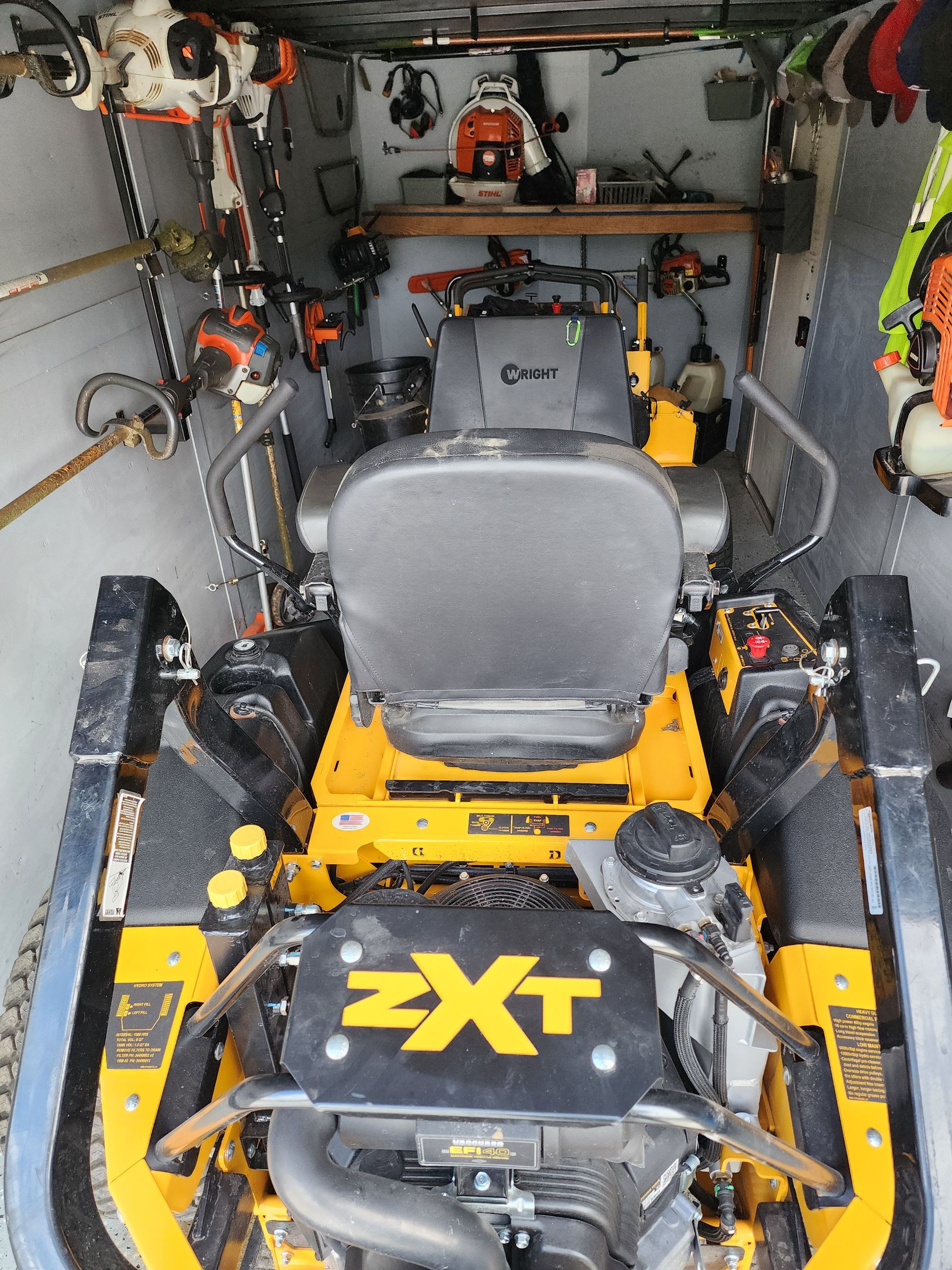 A yellow lawn mower with the word ext on the engine