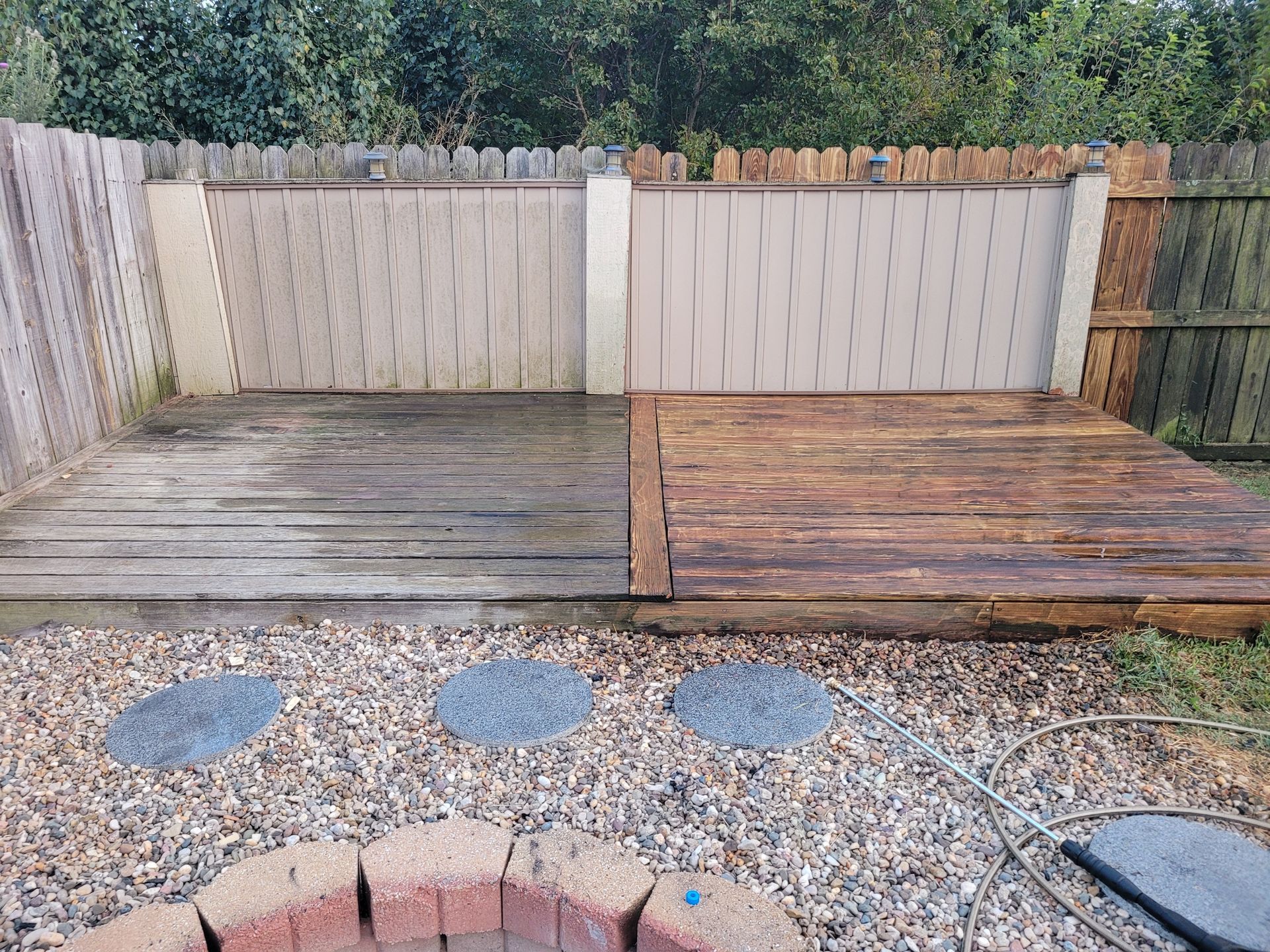 A wooden fence is in the backyard of a house.