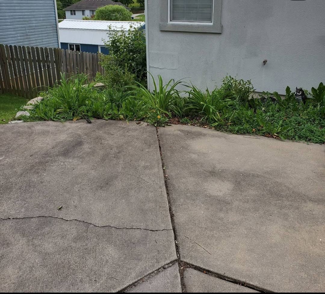 A concrete driveway in front of a white house