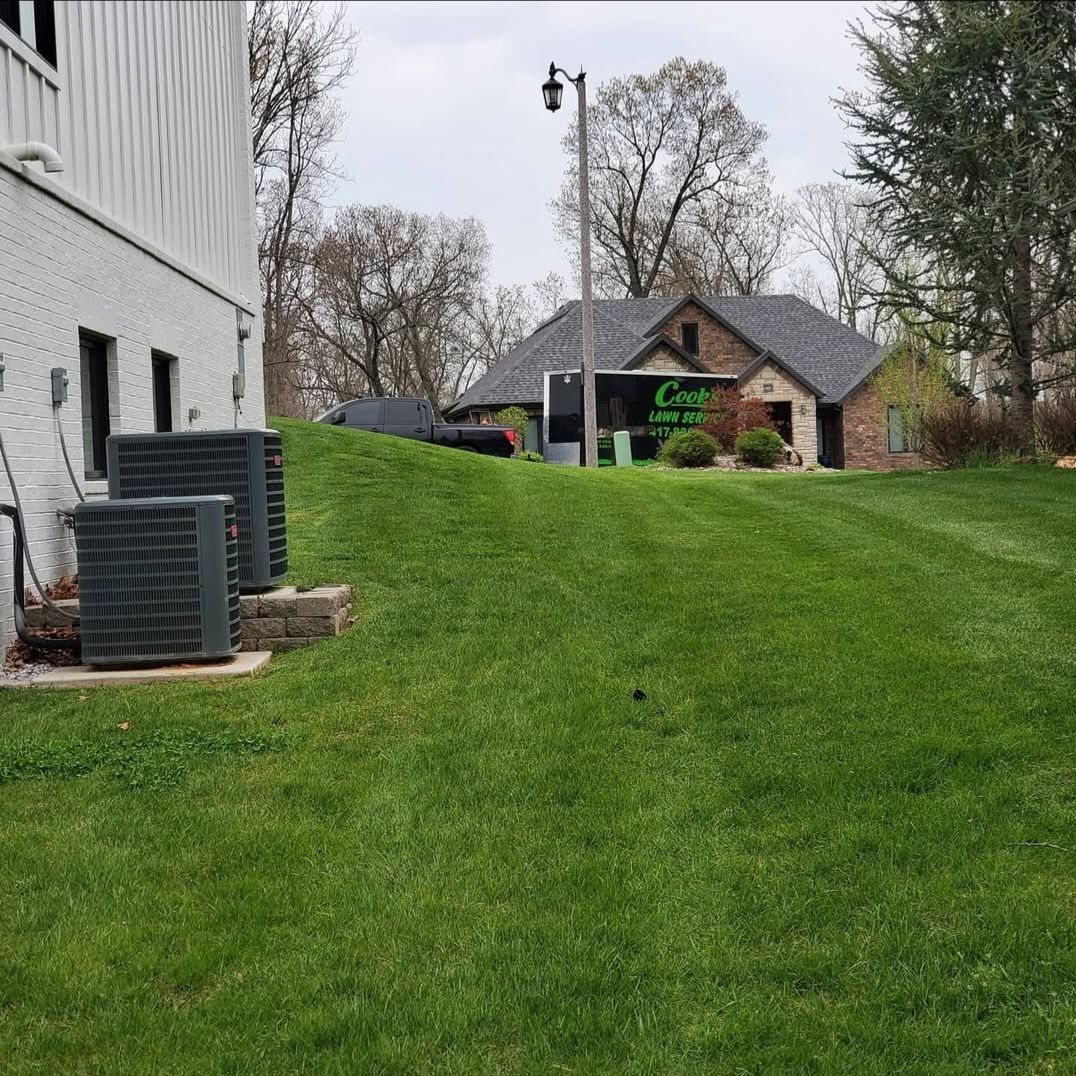 A lush green lawn with a white building in the background.